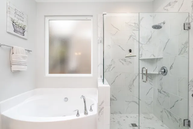 a white bath tub sitting next to a shower