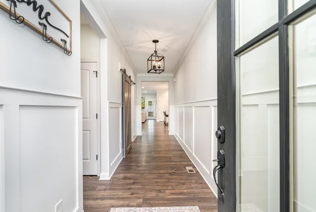a view of a hallway with wooden floor and staircase