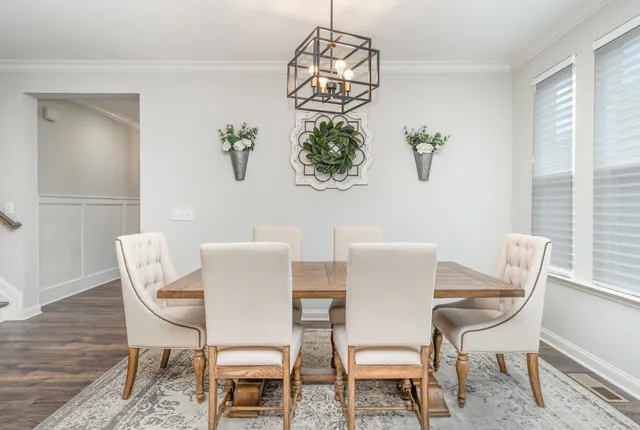 a view of a dining room with furniture a chandelier and wooden floor