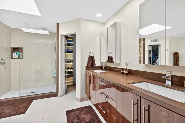 a spacious bathroom with a double vanity sink a mirror and shower