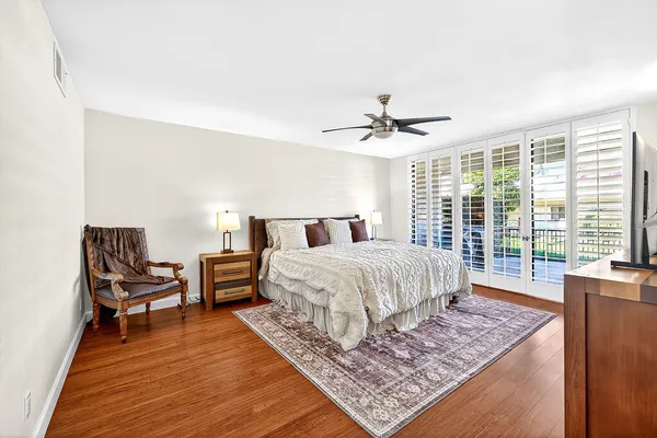 a bedroom with a bed a flat screen tv and dresser