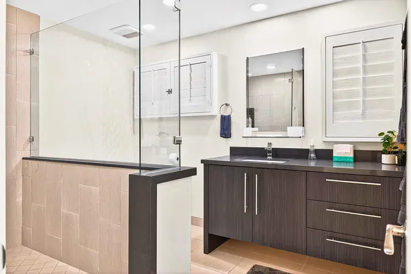 a bedroom with a bed and a flat tv screen on dresser