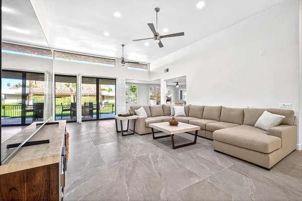 a living room with furniture and large windows