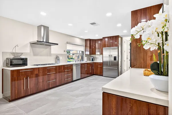 a kitchen with stainless steel appliances granite countertop a sink refrigerator and cabinets