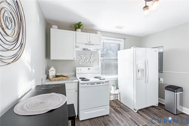 a kitchen with stainless steel appliances a white refrigerator stove a sink and dishwasher with wooden floor