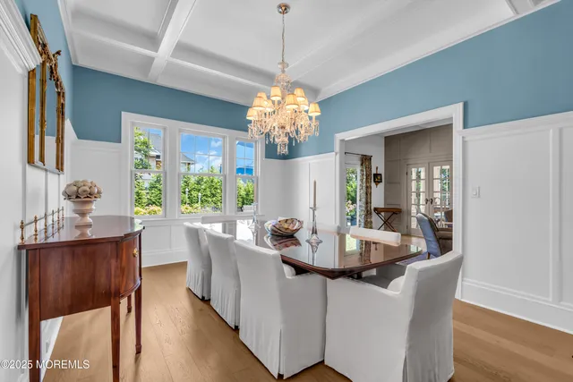 a dining room with furniture a chandelier and wooden floor