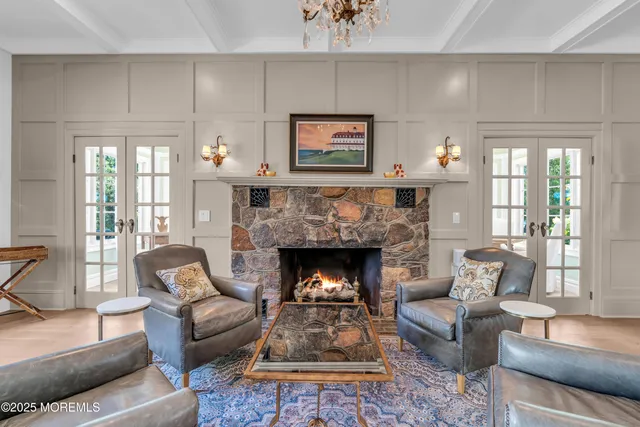 a living room with furniture a fireplace and a chandelier