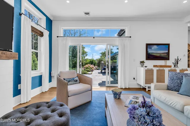 a living room with furniture a flat screen tv and a large window