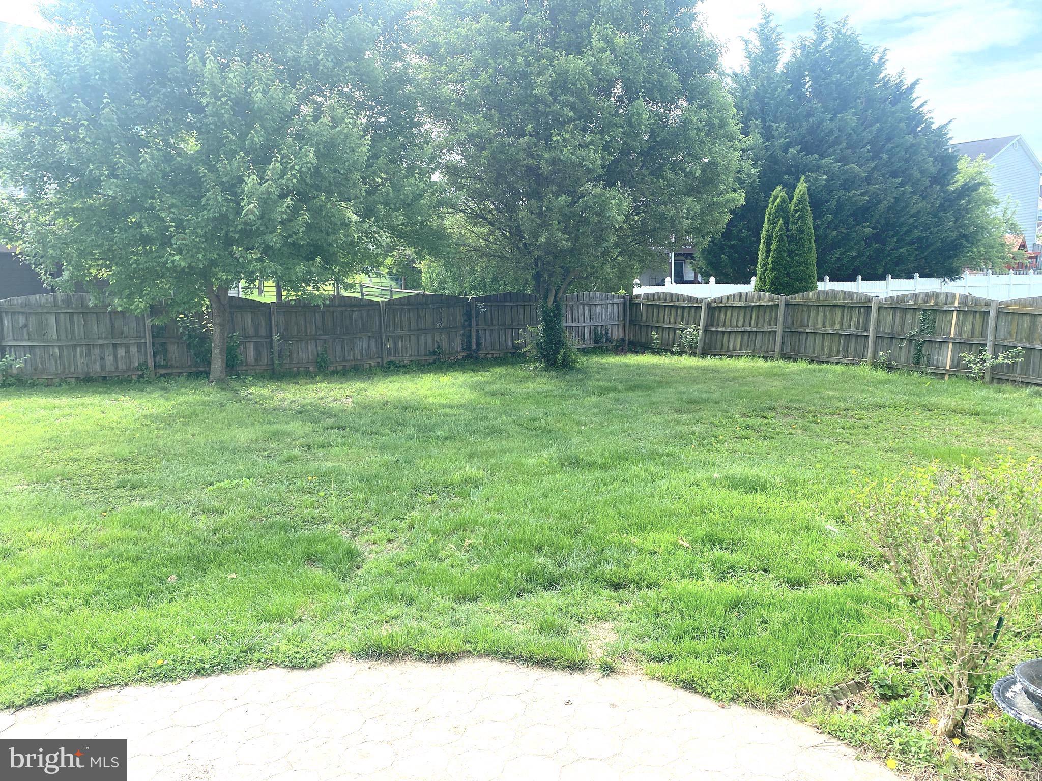 172 Jack Rabbit Lane Ranson, WV 25438 - Photo 7 of 34 a backyard of a house with trees and wooden fence