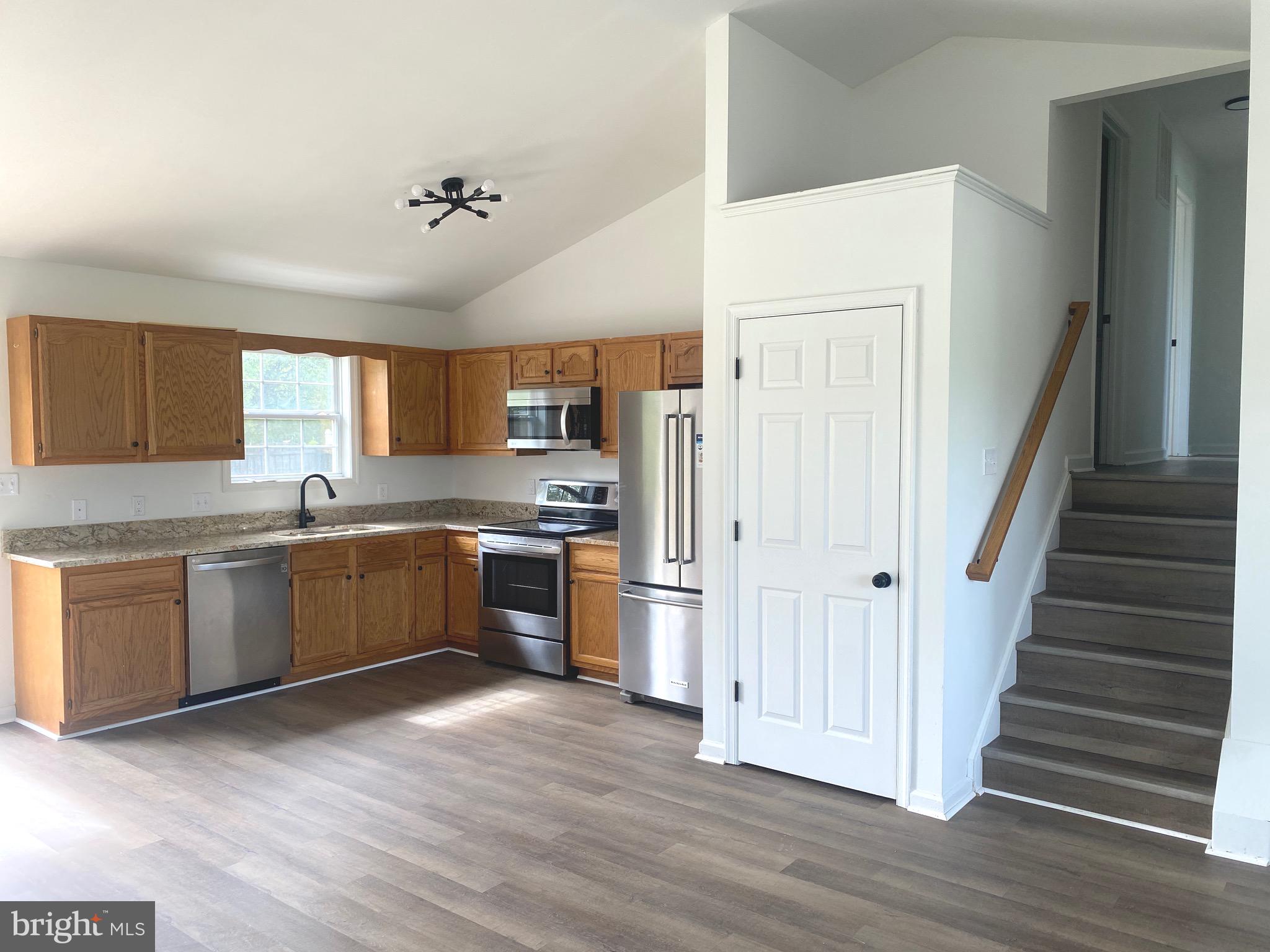 172 Jack Rabbit Lane Ranson, WV 25438 - Photo 9 of 34 a large kitchen with a refrigerator a sink dishwasher a stove and a microwave oven on the wooden floor