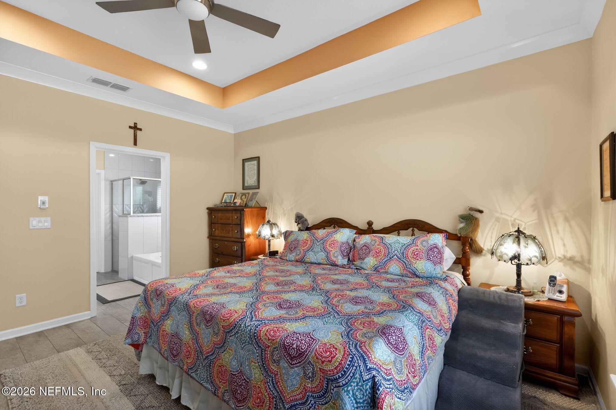 96017 Breezeway Court Yulee, FL 32097 - Photo 16 of 30 a bedroom with a bed and a chandelier