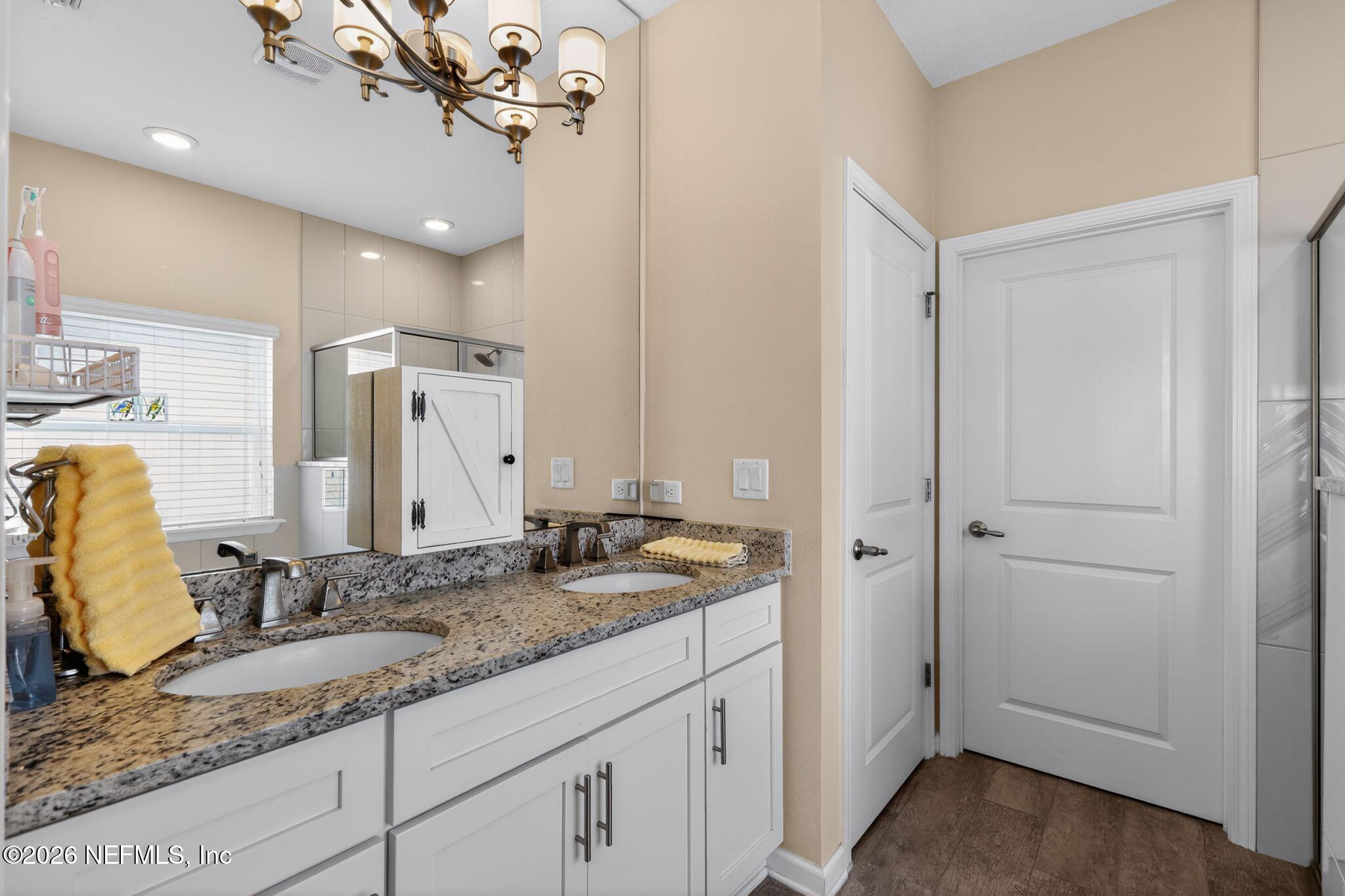 96017 Breezeway Court Yulee, FL 32097 - Photo 19 of 30 a bathroom with a granite countertop sink and a mirror