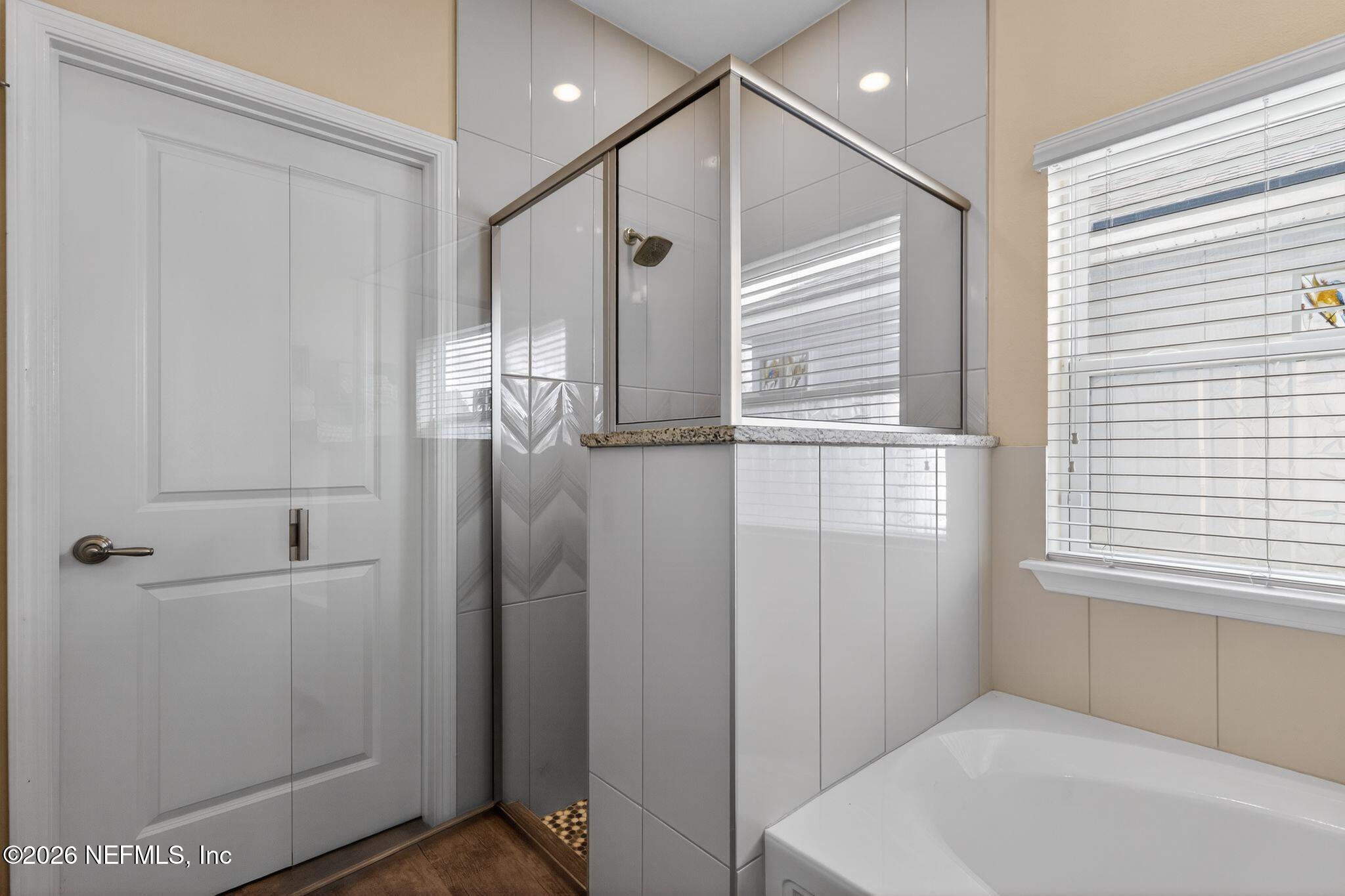 96017 Breezeway Court Yulee, FL 32097 - Photo 20 of 30 a bathroom with a bathtub and a shower