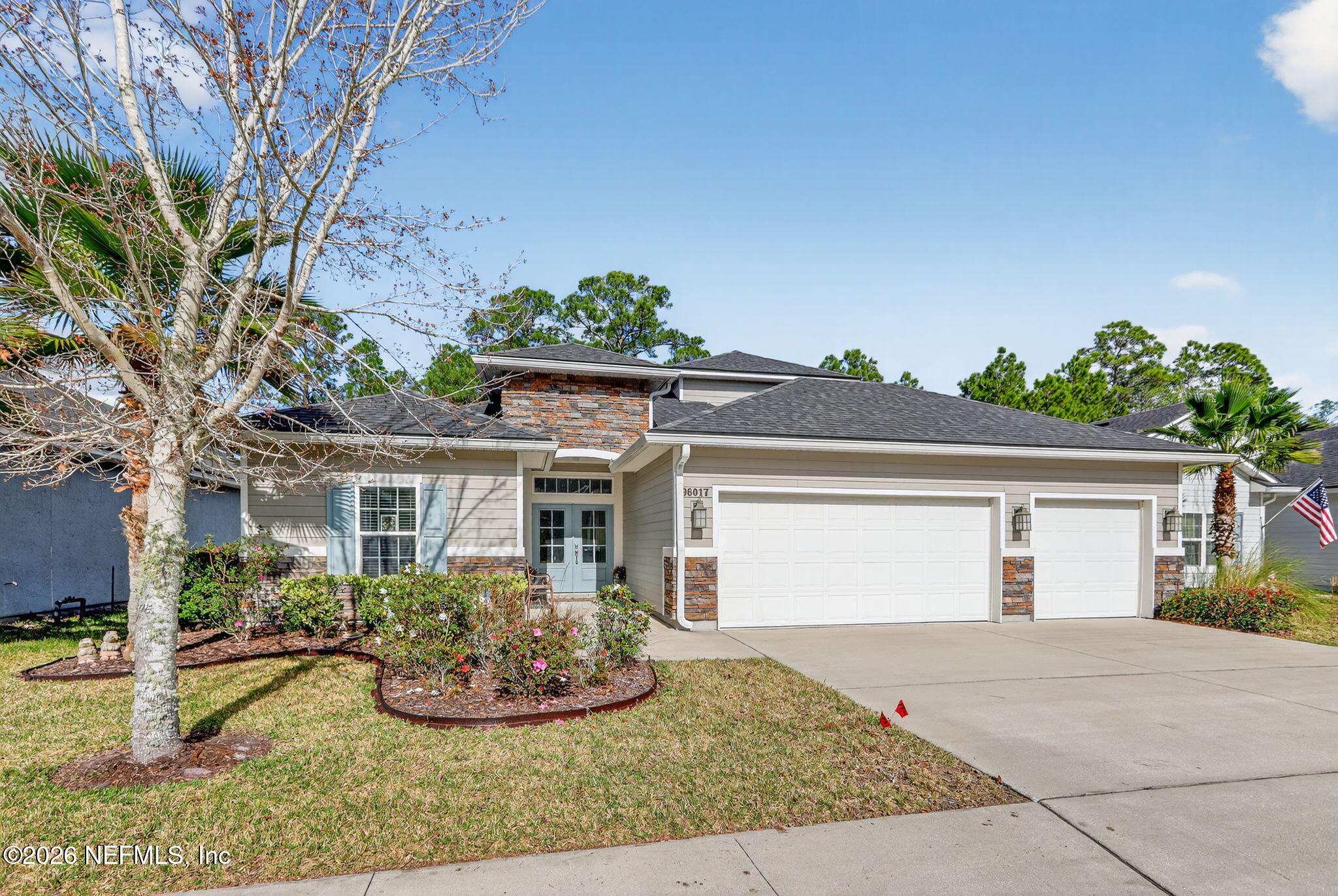 96017 Breezeway Court Yulee, FL 32097 - Photo 2 of 30 a front view of a house with garden