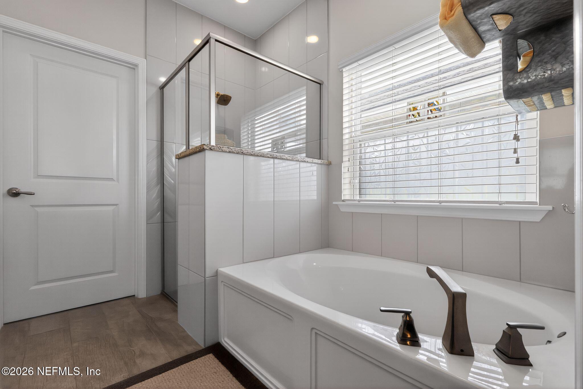 96017 Breezeway Court Yulee, FL 32097 - Photo 21 of 30 a bathroom with a tub a sink and a window