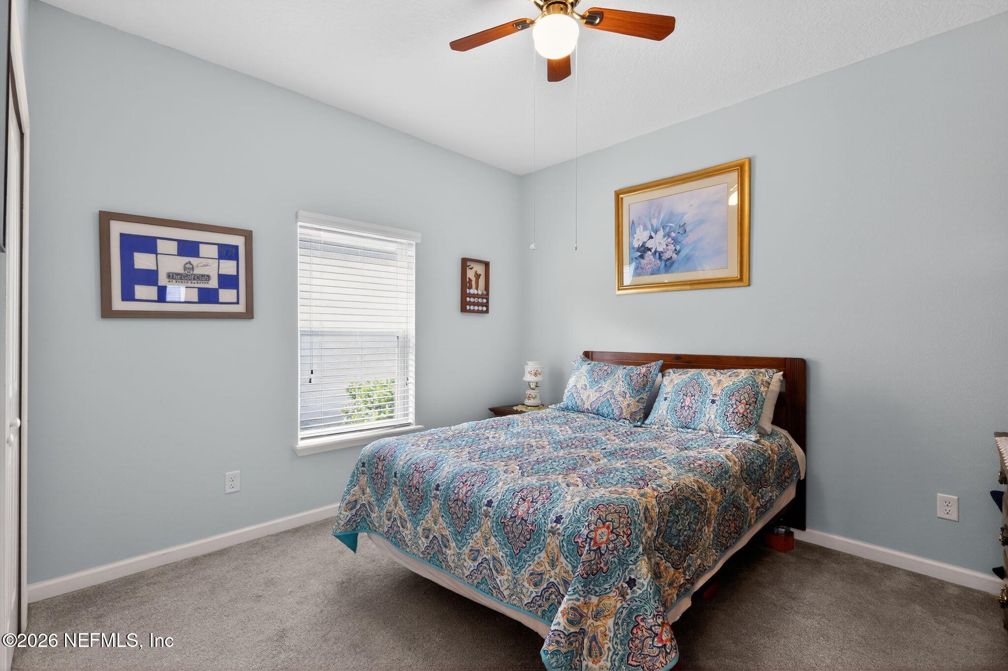 96017 Breezeway Court Yulee, FL 32097 - Photo 22 of 30 a bedroom with a bed and a painting on the wall
