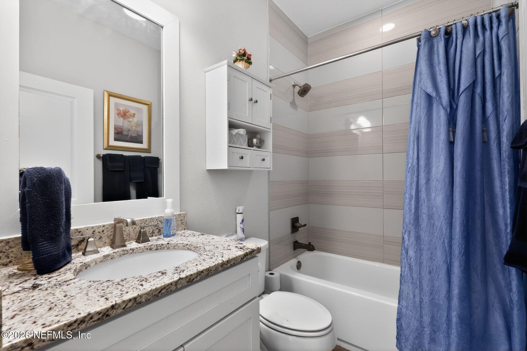 96017 Breezeway Court Yulee, FL 32097 - Photo 24 of 30 a bathroom with a granite countertop bathtub shower sink vanity and toilet