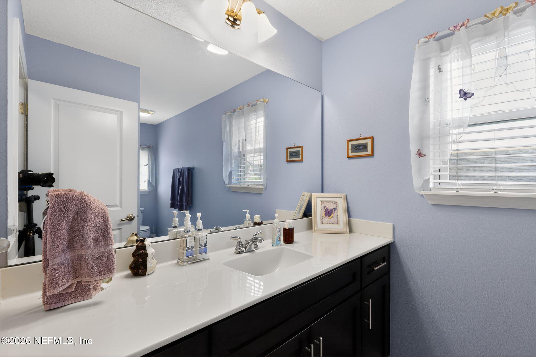 96017 Breezeway Court Yulee, FL 32097 - Photo 26 of 30 a bathroom with double vanity sink and a mirror