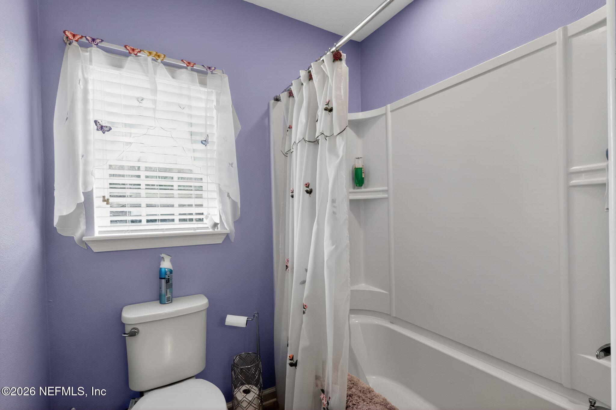 96017 Breezeway Court Yulee, FL 32097 - Photo 27 of 30 a bathroom with a bathtub shower sink vanity and a toilet