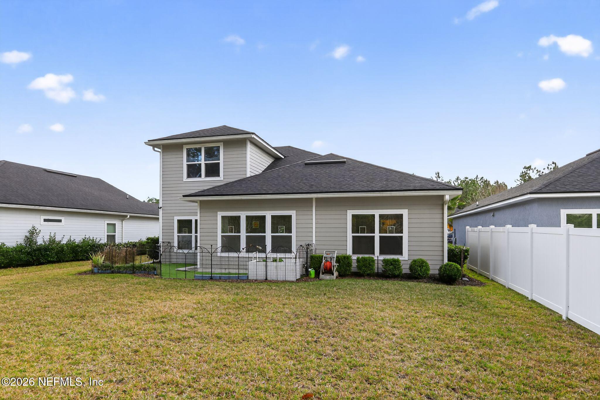 96017 Breezeway Court Yulee, FL 32097 - Photo 3 of 30 a front view of a house with a garden