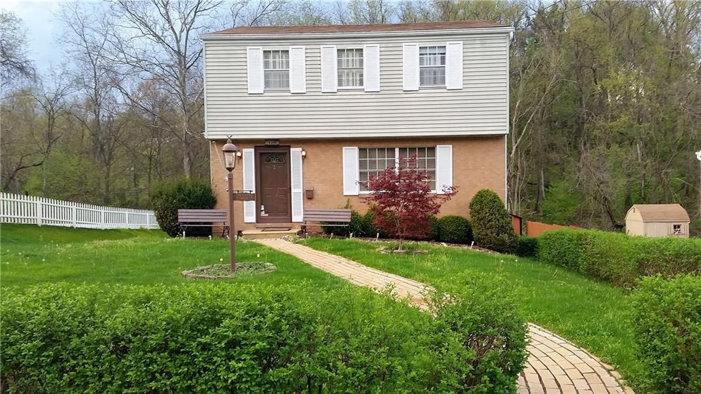 Front of home with Red Maple tree, welcoming benches and light, winding brick path and picket fence!