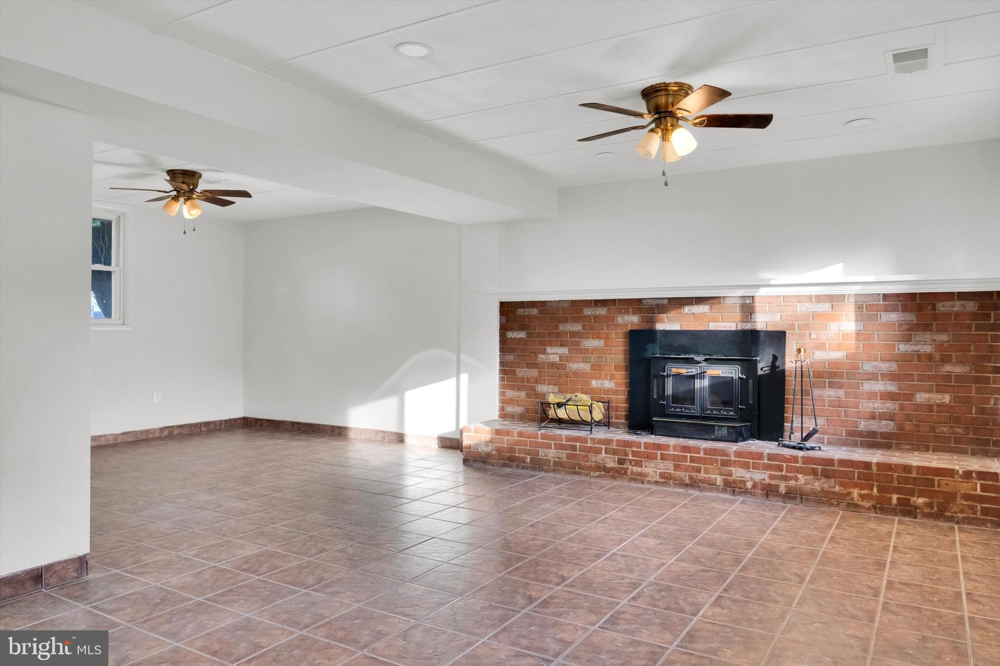 4224 Kinmount Road Lanham, MD 20706 - Photo 31 of 45 an empty room with a fireplace and fan