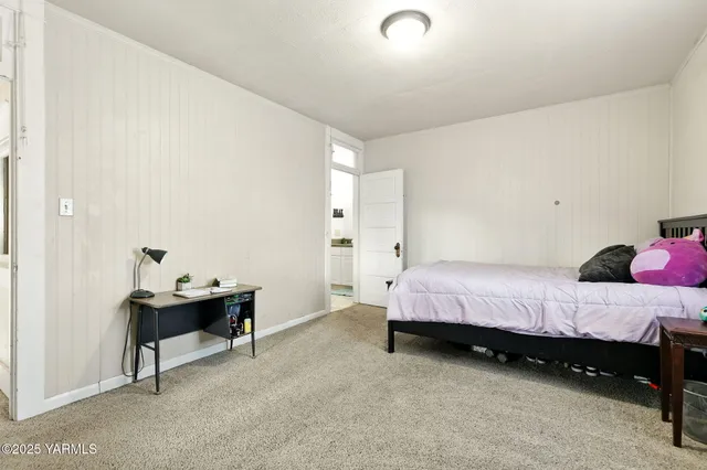 a bedroom with a bed and a table chair