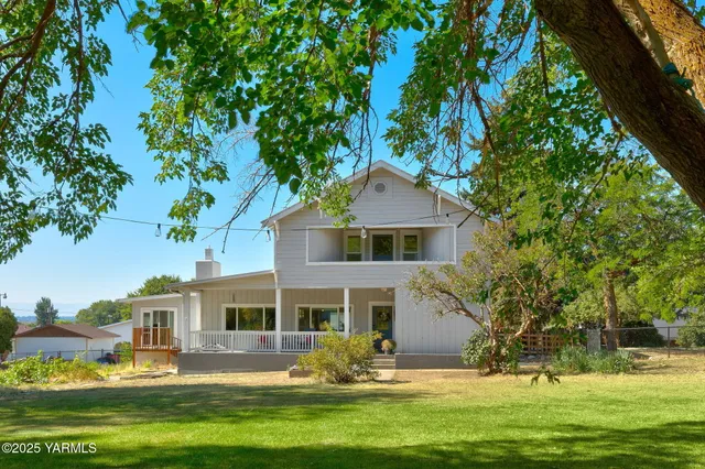 a front view of a house with a garden and trees