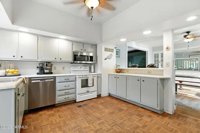 a kitchen with white cabinets and appliances
