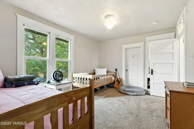 a bedroom with furniture and a large window