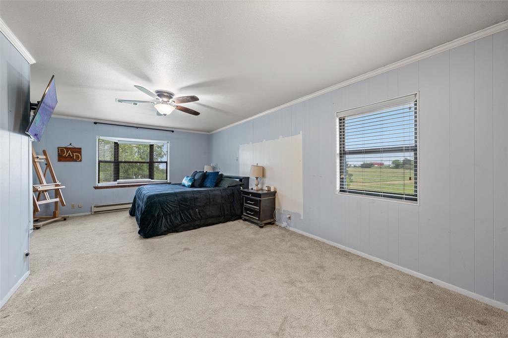 608 West Spring Street West, TX 76691 - Photo 15 of 27 a spacious bedroom with a bed and a walk in closet