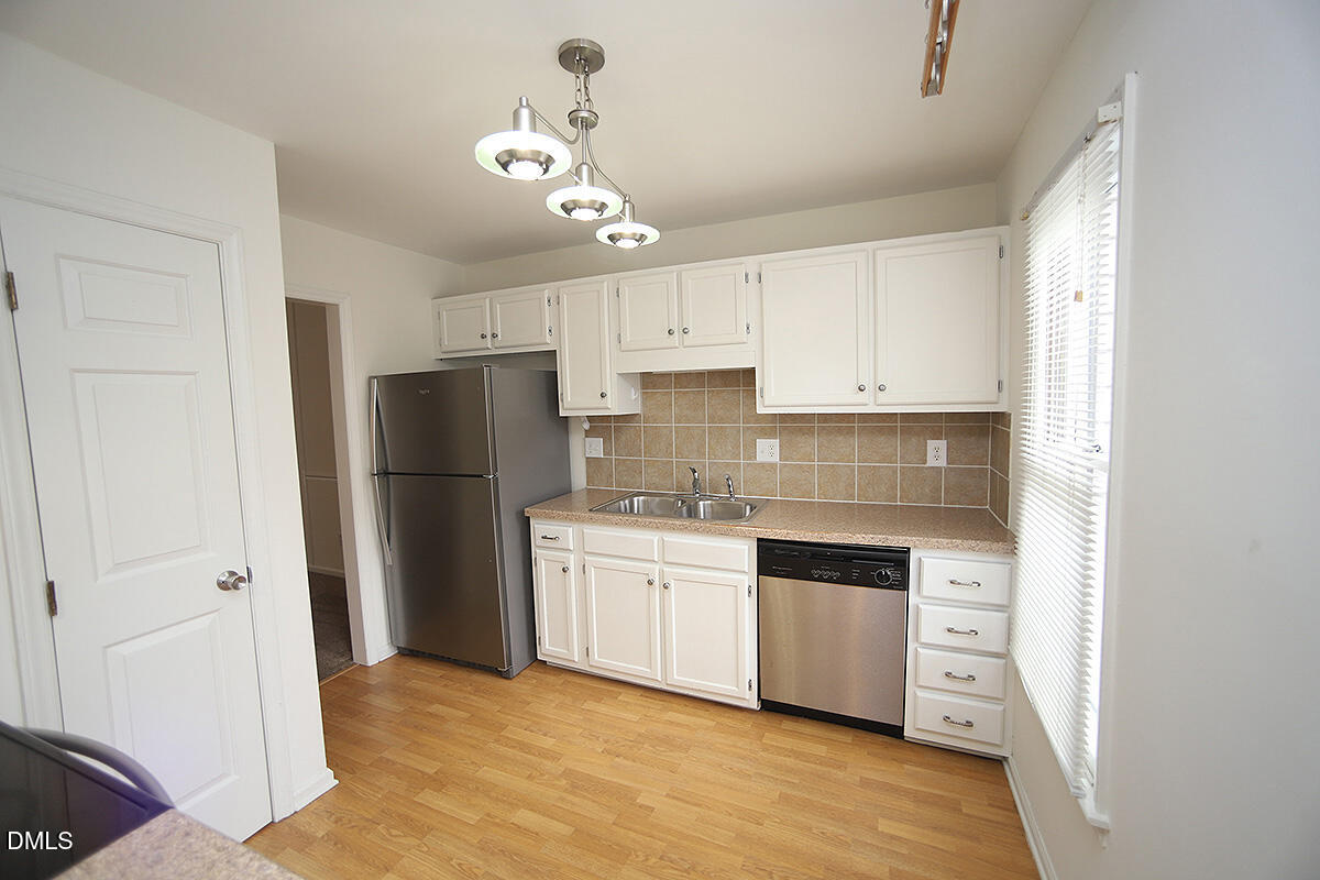 6514 Hearthstone Drive Raleigh, NC 27615 - Photo 2 of 16 a kitchen with stainless steel appliances a refrigerator a sink and white cabinets