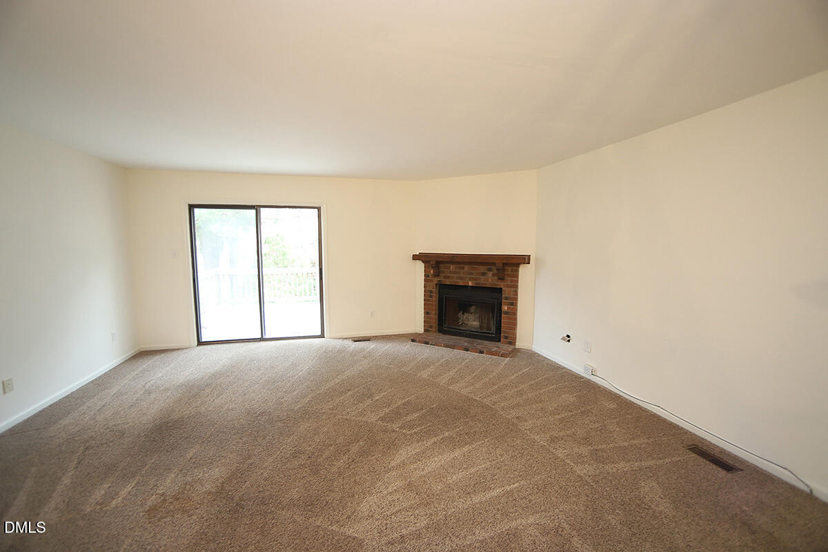 6514 Hearthstone Drive Raleigh, NC 27615 - Photo 6 of 16 an empty room with a fireplace