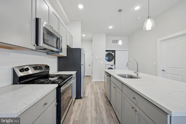 a kitchen with stainless steel appliances a sink stove and refrigerator