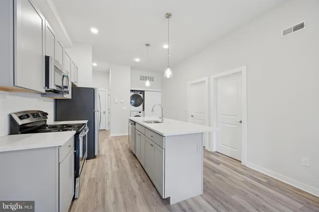 a kitchen with white cabinets sink and stainless steel appliances
