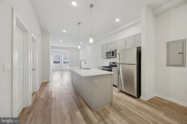 a kitchen with stainless steel appliances a refrigerator sink and cabinets