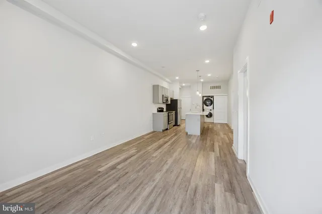 a view of a big room with wooden floor and windows