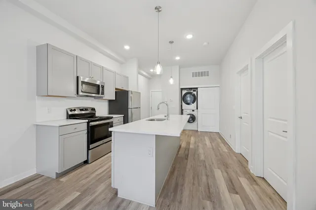 a view of kitchen with microwave a stove and wooden floor