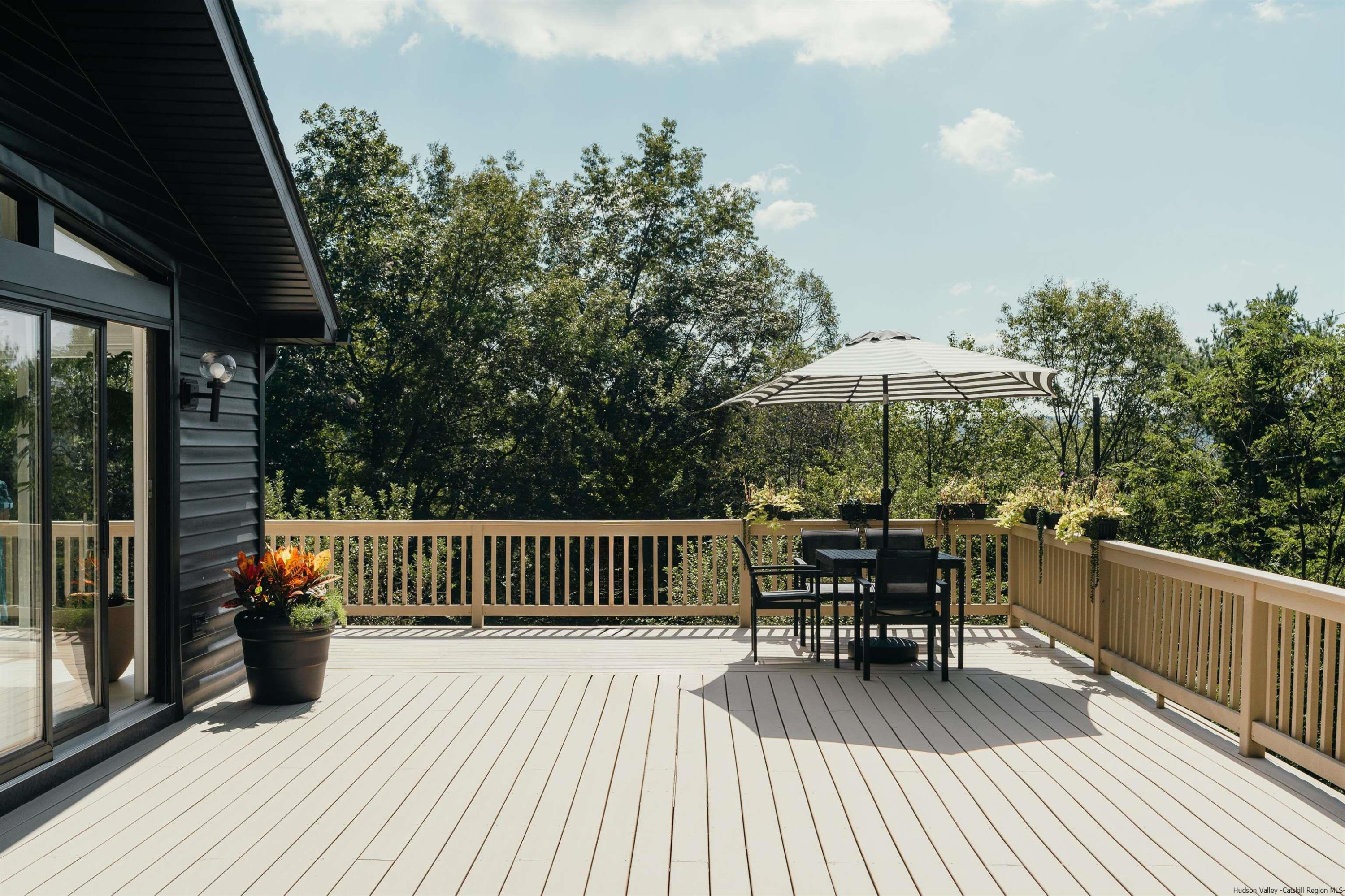187 Bloom Road Barryville, NY 12719 - Photo 8 of 35 a view of a roof deck with table and chairs and wooden floor