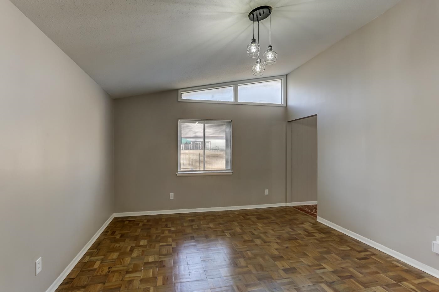 5244 Whitworth Road Memphis, TN 38116 - Photo 4 of 14 an empty room with wooden floor chandelier and windows
