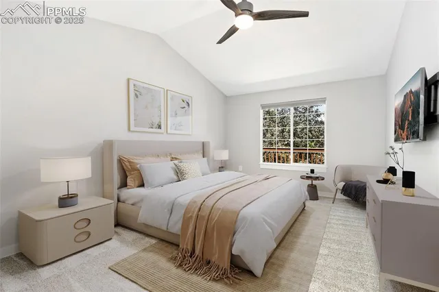 a spacious bedroom with a bed a couch and a flat tv screen on the dresser