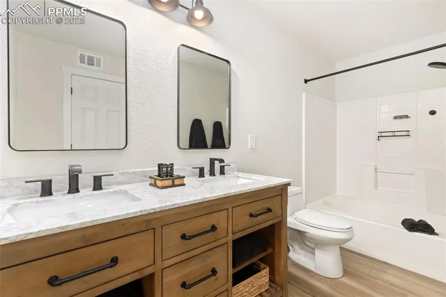 a bathroom with a granite countertop toilet sink and a mirror