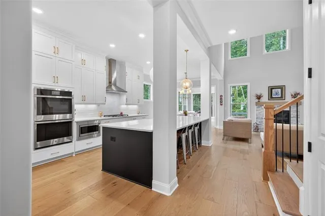 a large kitchen with kitchen island a large counter space a sink a window and stainless steel appliances
