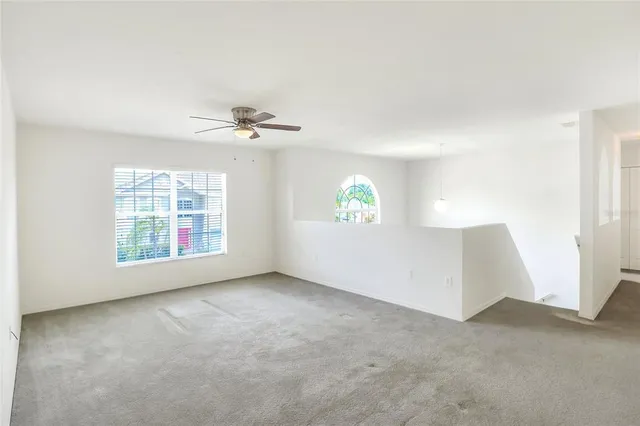 an empty room with fan and windows