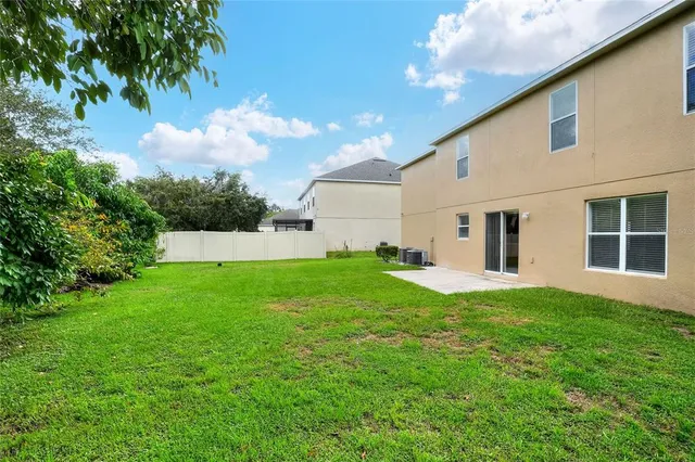 a front view of a house with a yard and potted plants