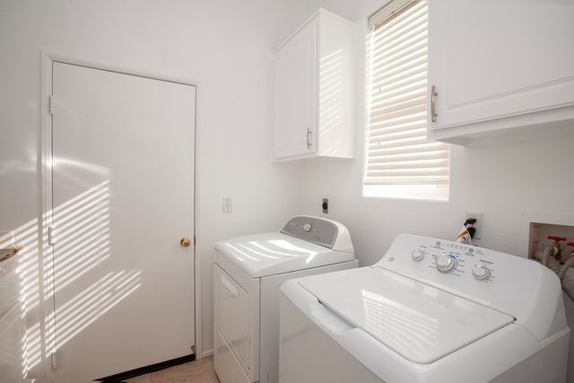 a front view of a house with a yard and potted plants