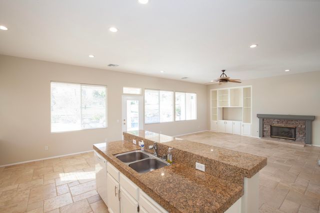 a kitchen with stainless steel appliances granite countertop a sink a oven and a granite counter tops with a window