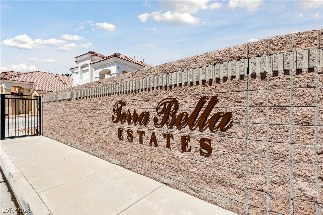 740 Aldo Rae Court, Unit NONE Henderson, NV 89052 - Photo 34 of 35 Secure community entry with a robust stone block wall and decorative wrought iron gate.