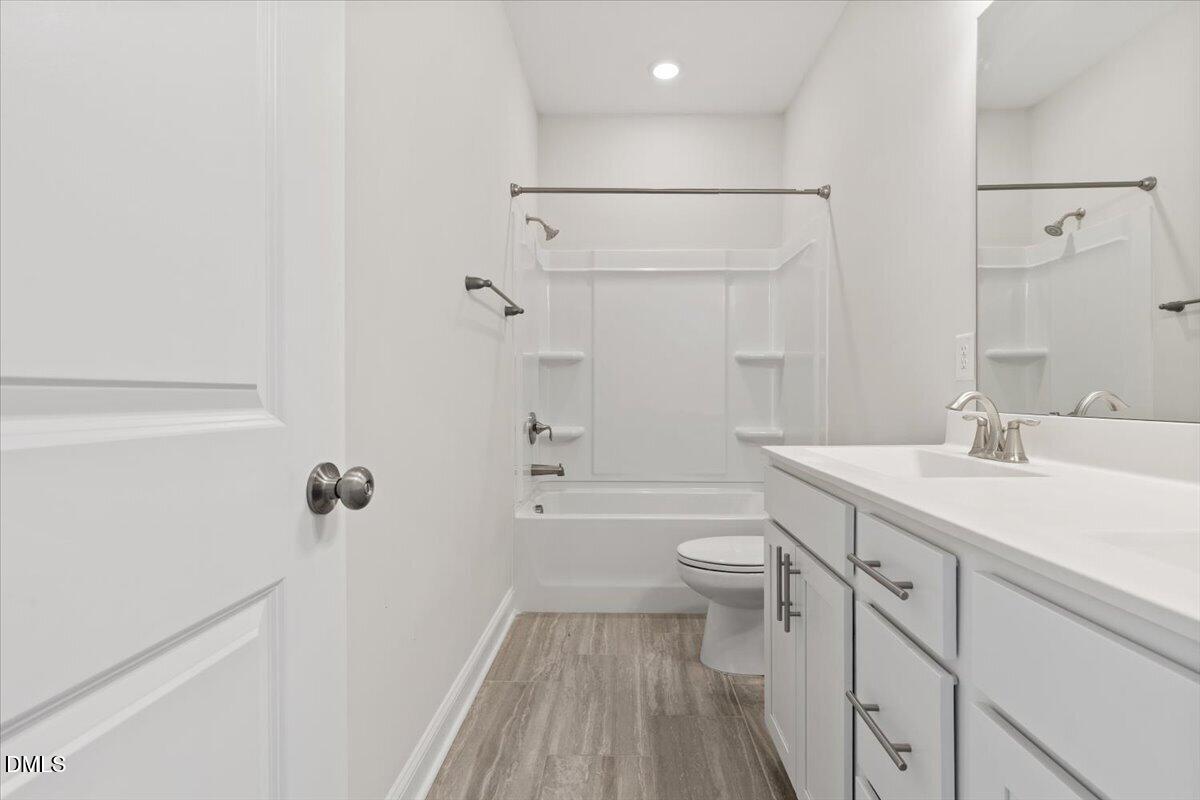 4937 Abundance Avenue Raleigh, NC 27616 - Photo 27 of 36 a bathroom with a sink a toilet a shower and a mirror