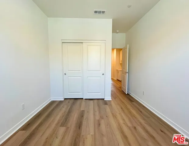 an empty room with wooden floor and a window